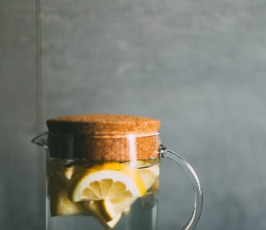 체중 증가를 막기 위한 간단한 식사 팁 clear glass pitcher filled with sliced lemons on black and white table runner