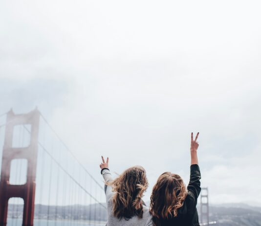 스트레스가 건강에 미치는 영향과 대처법 two women making peace sign near the Golden Gate bridge