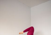 요가와 필라테스를 통한 스트레스와 면역력 관리 woman in white tank top and purple leggings doing yoga