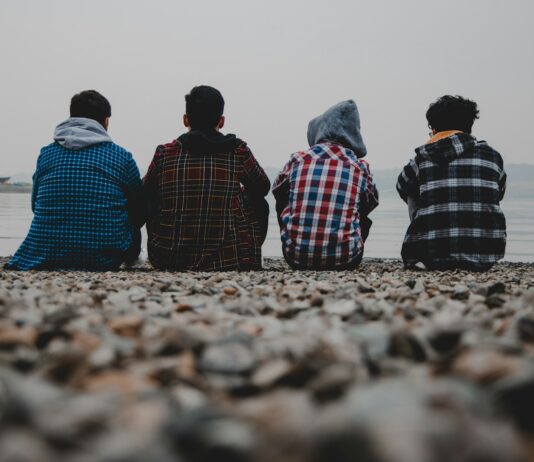 거리감 있는 친구와 친해지기 group of people sitting on white sand during daytime