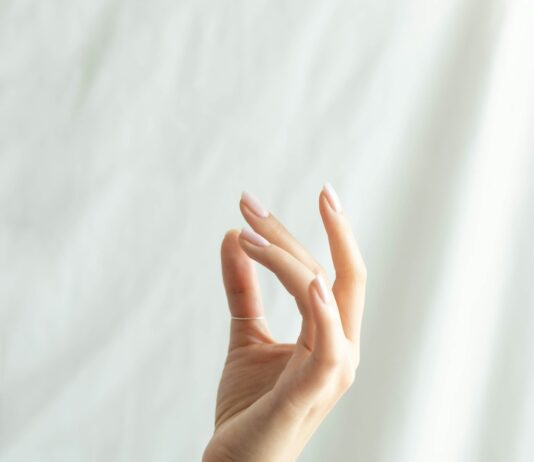 “손끝이 자주 저려요”…초여름 ‘혈액순환’이 불안할 때 persons left hand on white textile