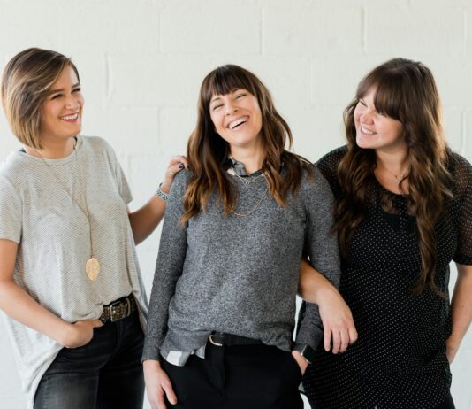 갱년기 증상 완화를 위한 5가지 호르몬 건강 팁 3 women smiling and standing beside white wall