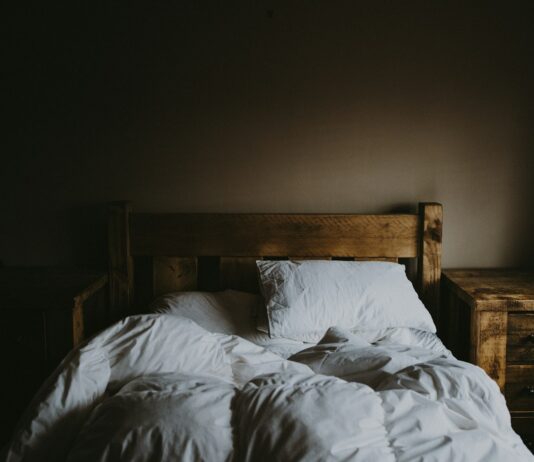 “현대인의 수면, 트렌드와 함께 달라진 슬립 루틴의 변화” white bed comforter set and brown wooden bed frame beside brown wooden nightstand