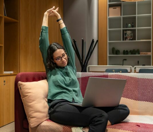 근육 건강, 생활 속에서 실천하는 새로운 트렌드 a woman sitting on a couch using a laptop