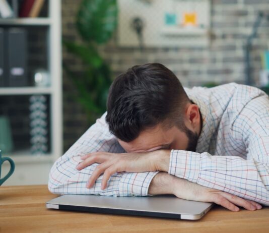 만성피로, 작은 습관으로 극복…나만의 리듬 찾는 실천 팁 주목 a man sitting at a desk with his head in his hands