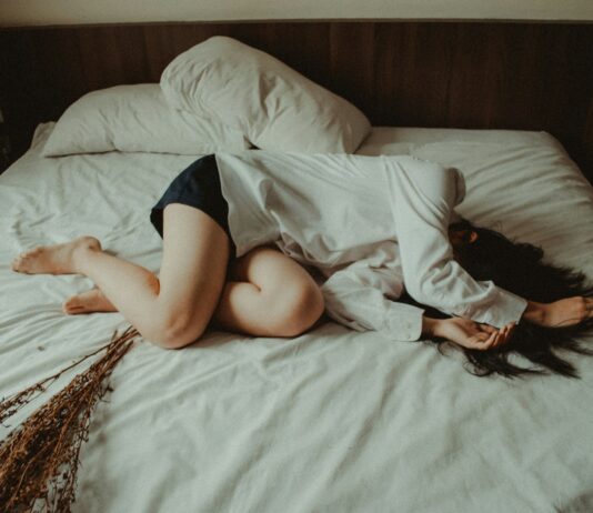 “일상이 힘들다면, 만성피로 자가 관리 루틴으로 활력 되찾기” woman lying on bed